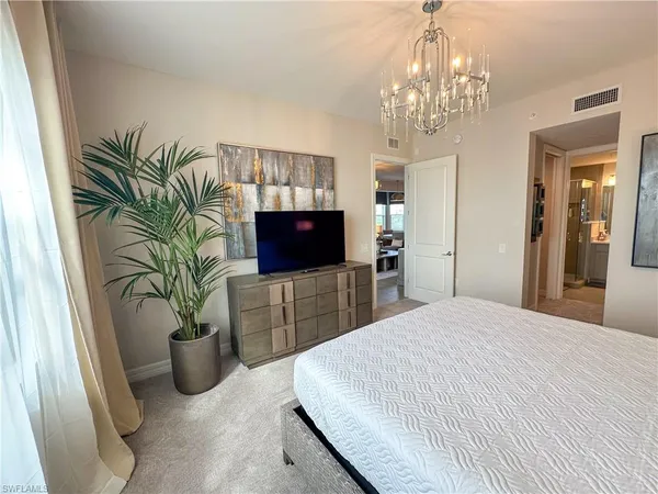 a bedroom with a bed and a large mirror on dresser