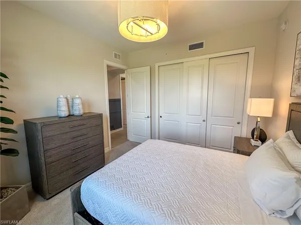 a bedroom with a bed and a potted plant