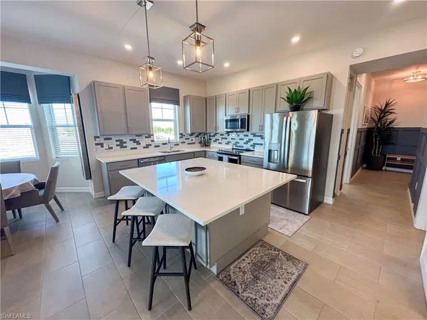 a kitchen with a dining table chairs and refrigerator