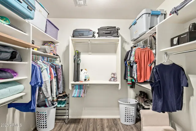 a view of walk in closet with clothes and shoes