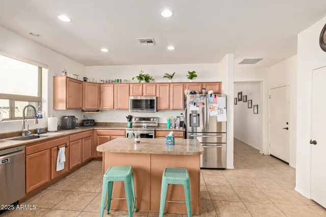 a kitchen with stainless steel appliances granite countertop a refrigerator and a stove top oven