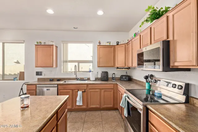 a kitchen with stainless steel appliances granite countertop a sink stove and cabinets