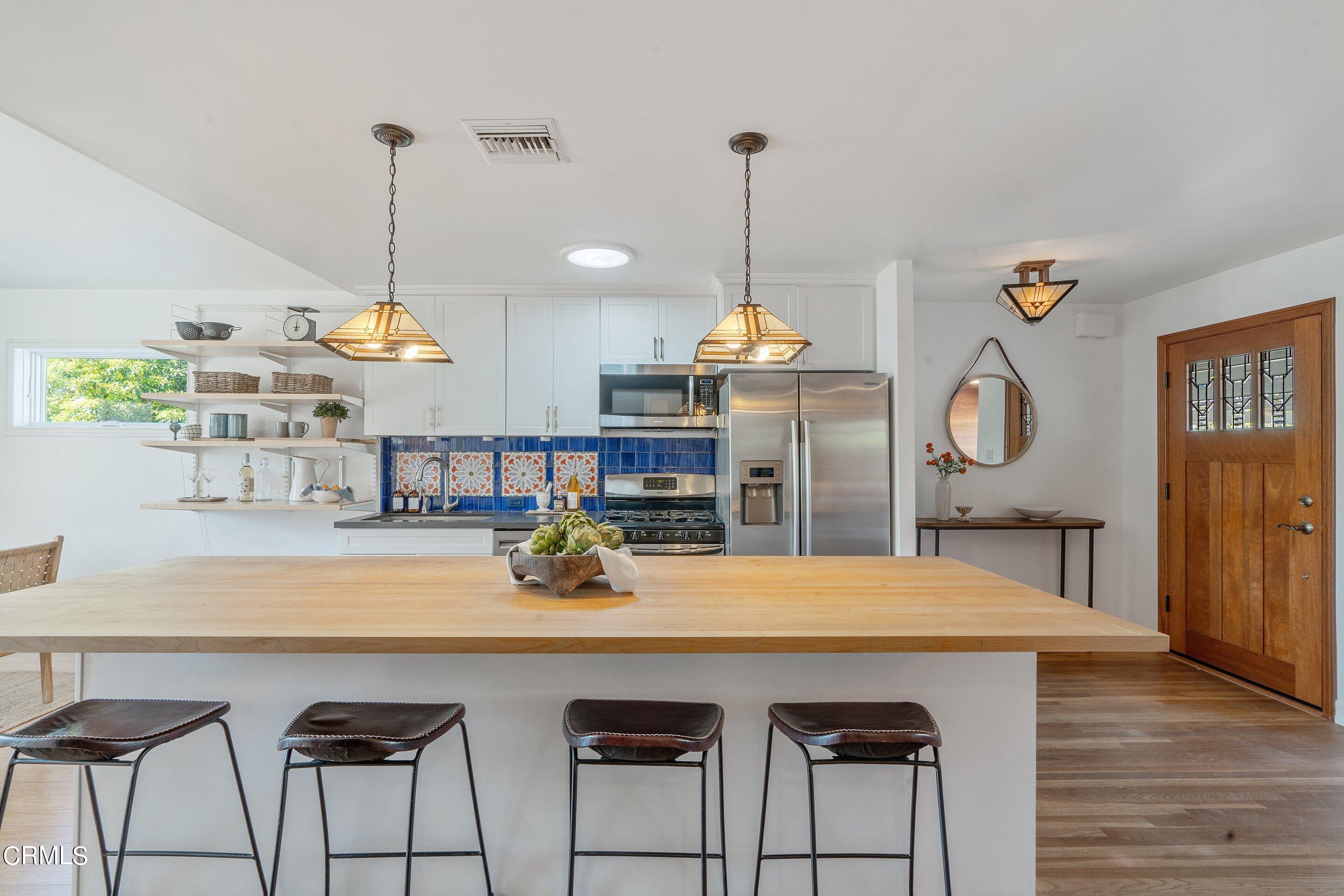1532 Atchison Street Pasadena, CA 91104 - Photo 14 of 45 a kitchen with a table a chandelier and wooden floor