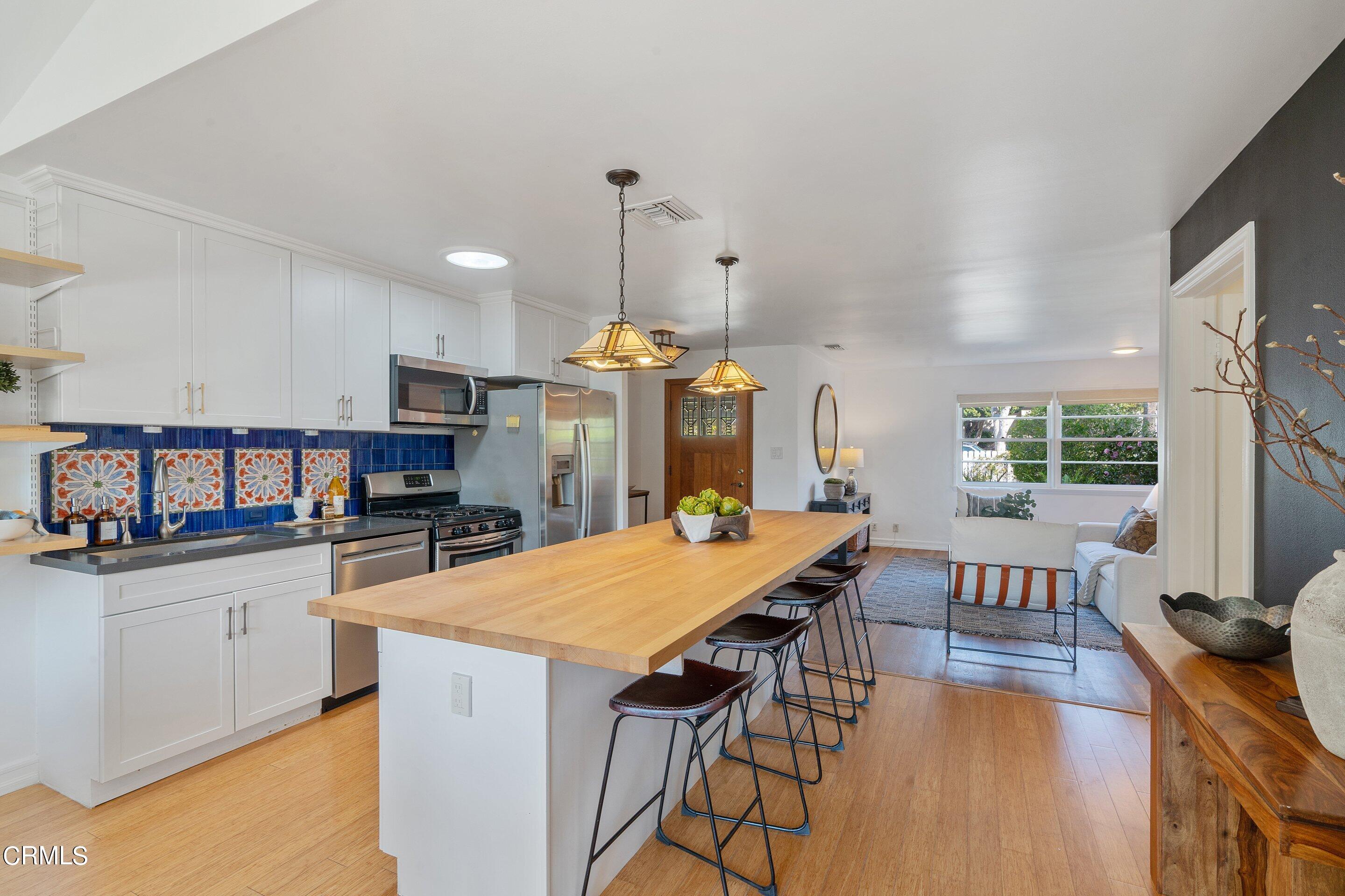 1532 Atchison Street Pasadena, CA 91104 - Photo 15 of 45 a large kitchen with granite countertop a stove a sink a dining table and chairs