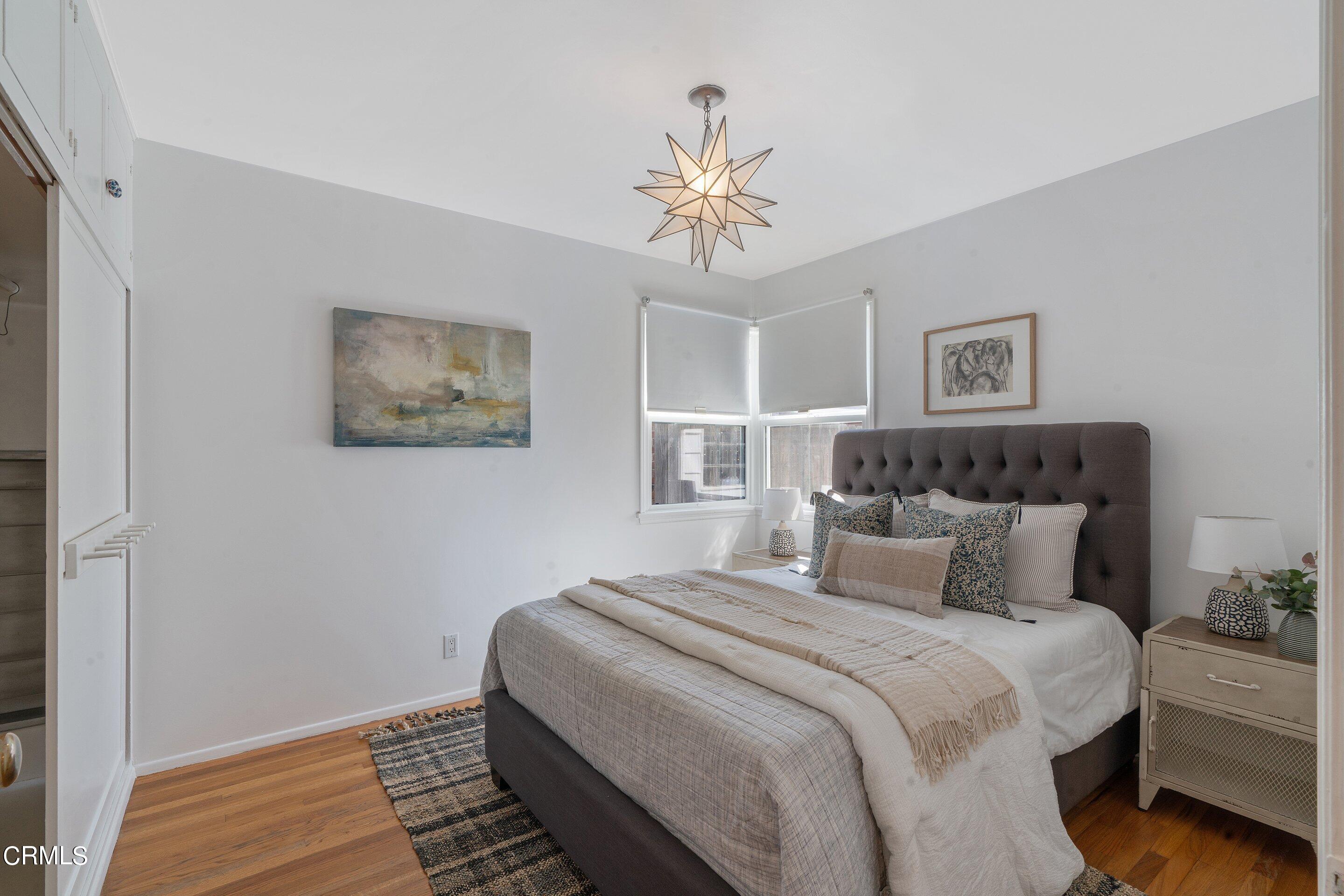 1532 Atchison Street Pasadena, CA 91104 - Photo 29 of 45 a bedroom with a large bed and a chandelier