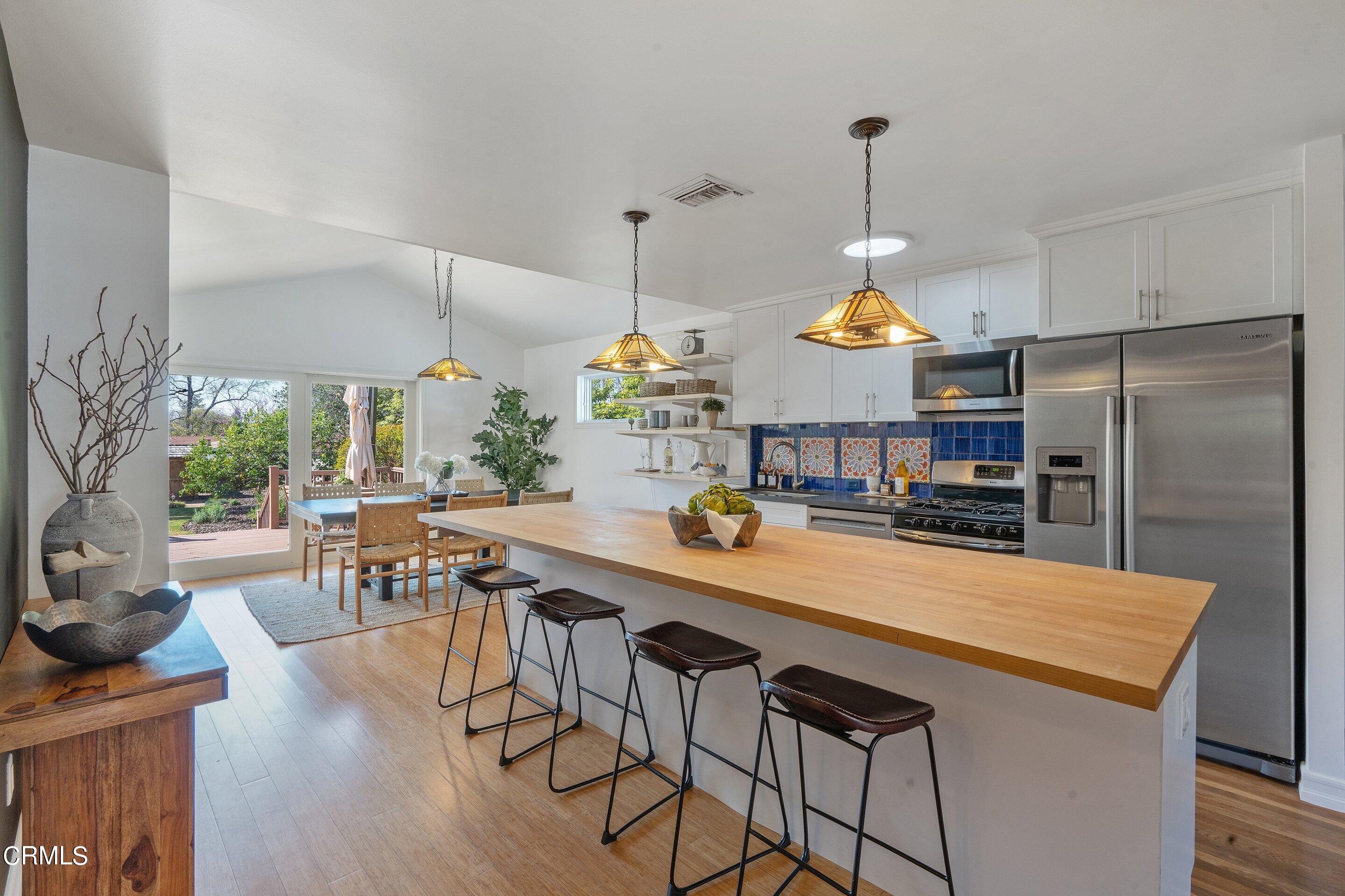 1532 Atchison Street Pasadena, CA 91104 - Photo 9 of 45 a kitchen with stainless steel appliances a dining table chairs and chandelier