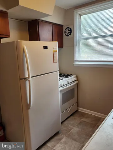 a white refrigerator freezer and a stove sitting inside of a kitchen