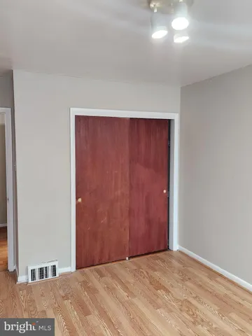 en empty room with wooden floor and chandelier