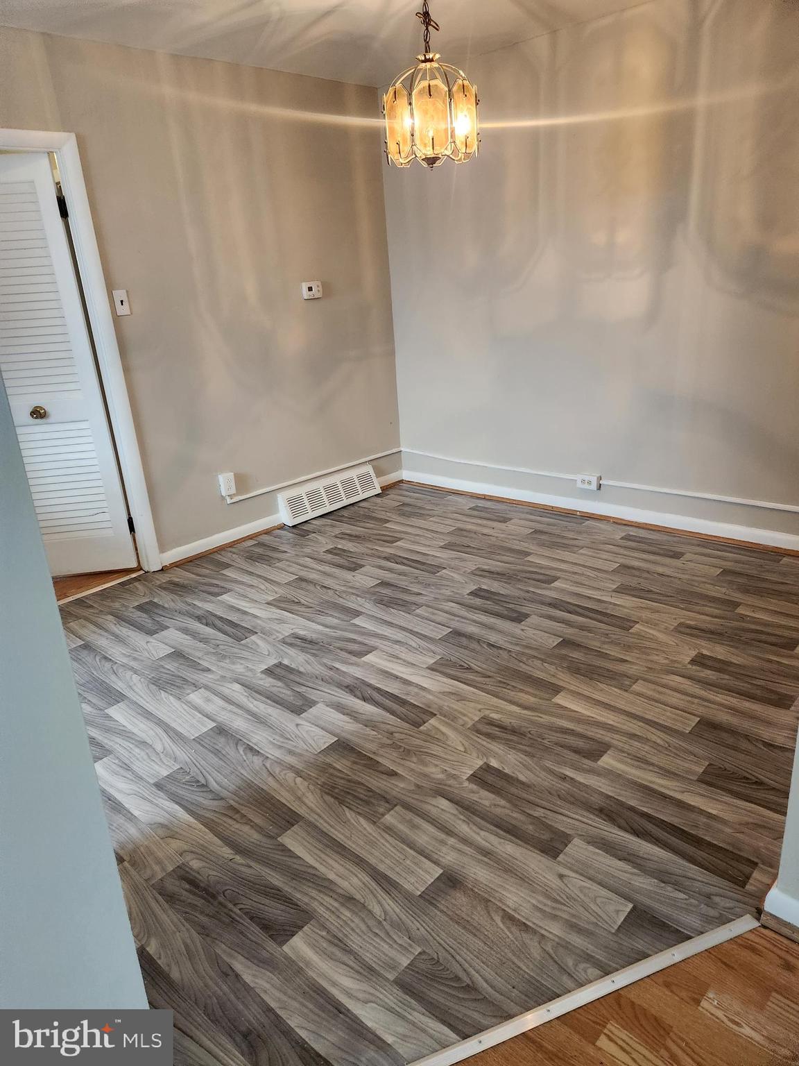 6651 Claridge Street Philadelphia, PA 19111 - Photo 21 of 26 en empty room with wooden floor and chandelier