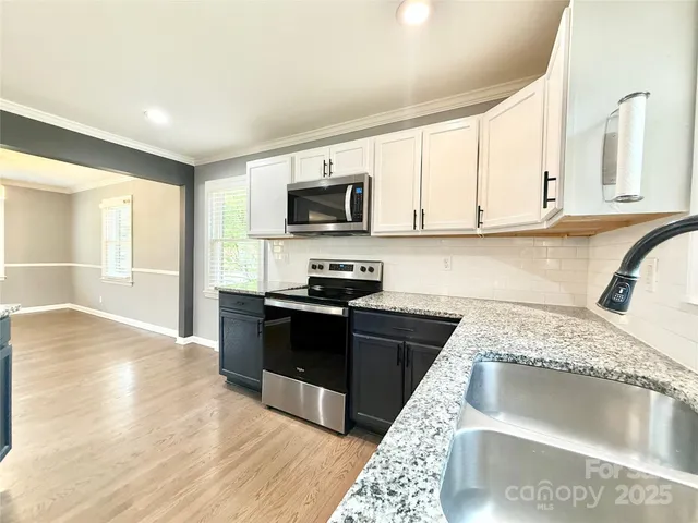 a kitchen with granite countertop a sink and a stove top oven