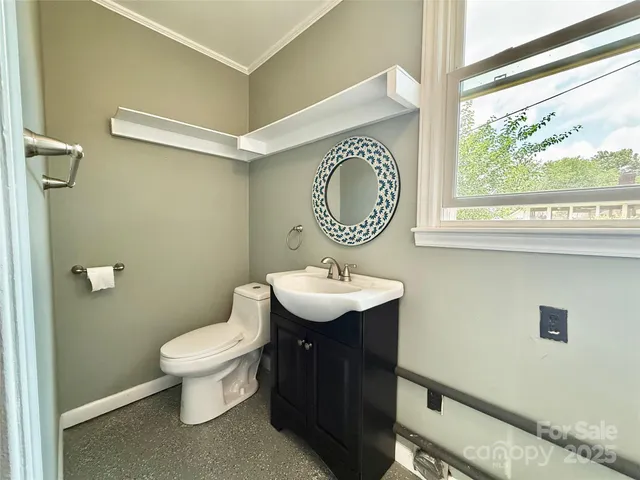 a bathroom with a sink a toilet and a window