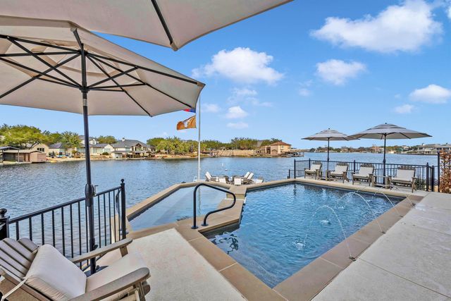 a view of a swimming pool with a table and chairs under an umbrella