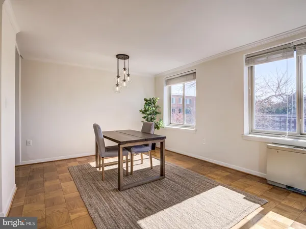 a dining room with wooden floor and a chandelier