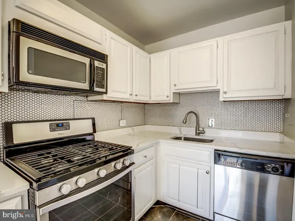 a kitchen with stainless steel appliances granite countertop a sink stove and microwave