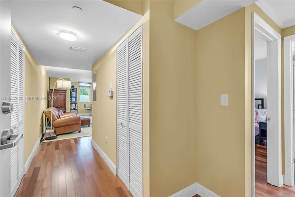 a view of a hallway with wooden floor and furniture