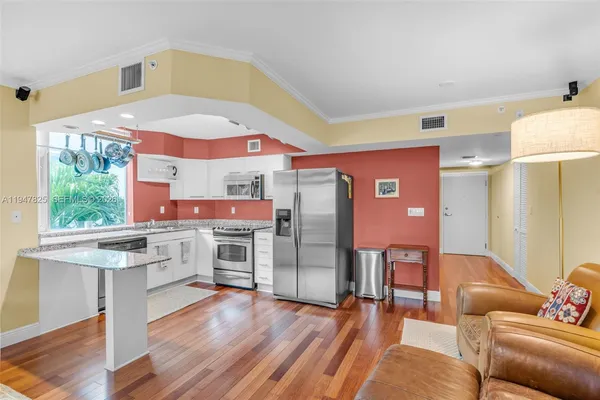 a living room with stainless steel appliances kitchen island granite countertop furniture and a large window
