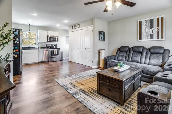 a living room with furniture and view of kitchen