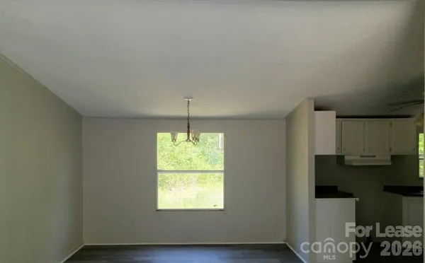 a kitchen with stainless steel appliances a window and wooden floor
