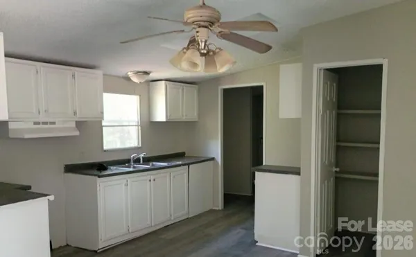 a kitchen with a refrigerator a stove cabinets and a dining table