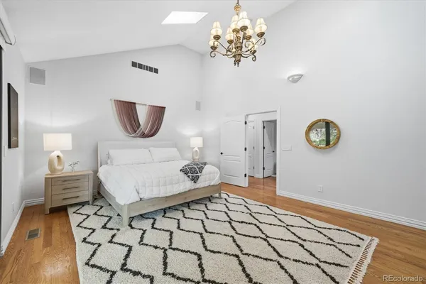 a bedroom with a bed and a table with wooden floor