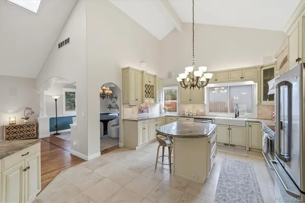 a dining hall with granite countertop a sink dishwasher a dining table and chairs with wooden floor