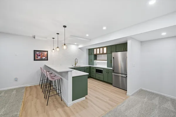 a kitchen with granite countertop a refrigerator and a stove top oven