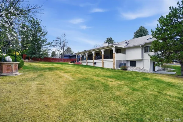 a view of a house with a big yard and large trees