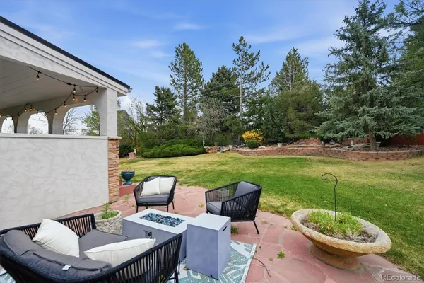 a view of a patio with couches table and chairs and potted plants