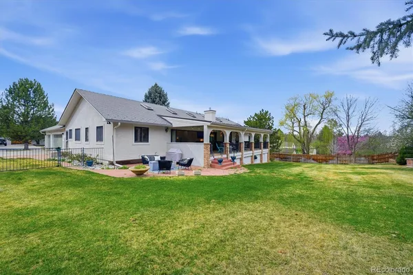 a front view of house with yard barbeque and outdoor seating