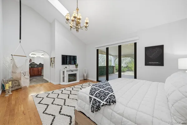 a large bedroom with a large bed and a flat tv screen on dresser