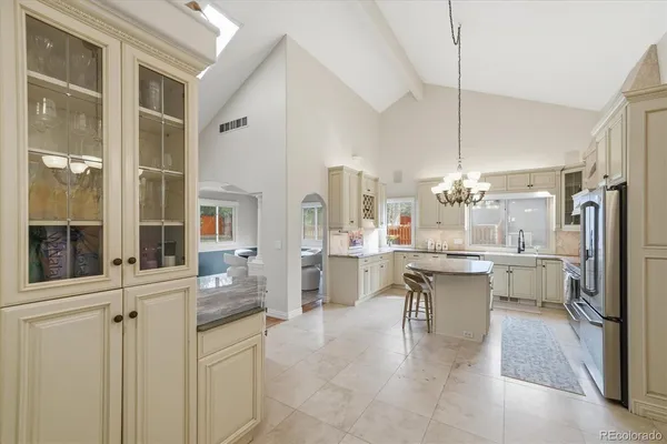 a large white kitchen with sink and wooden cabinets