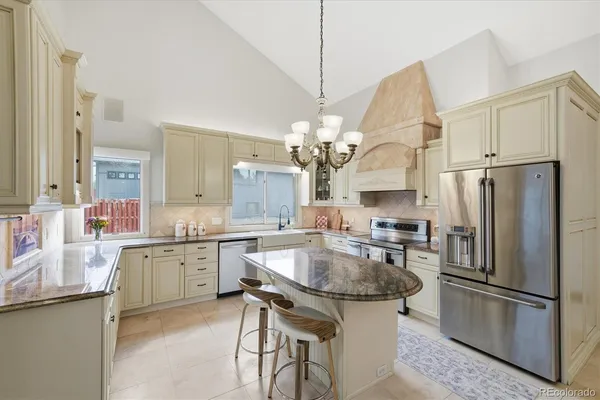 a kitchen with stainless steel appliances granite countertop a sink a stove and a refrigerator