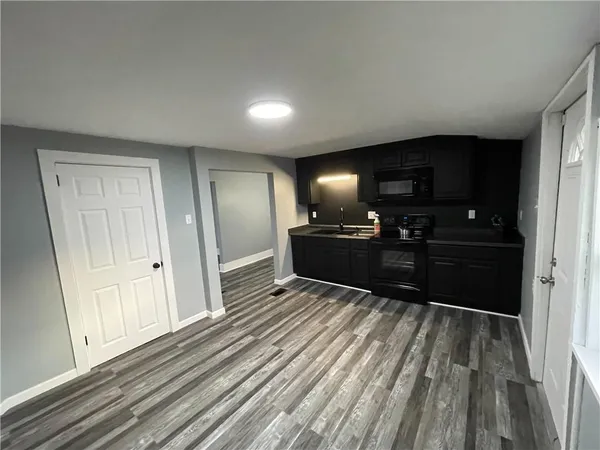 a view of kitchen with sink microwave and refrigerator