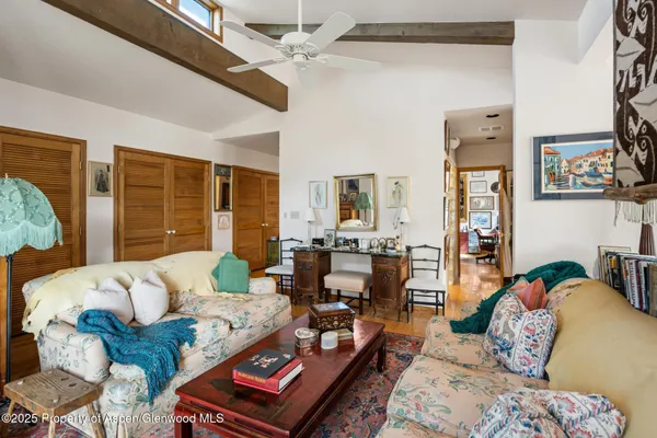 a living room with furniture a rug and a bookshelf