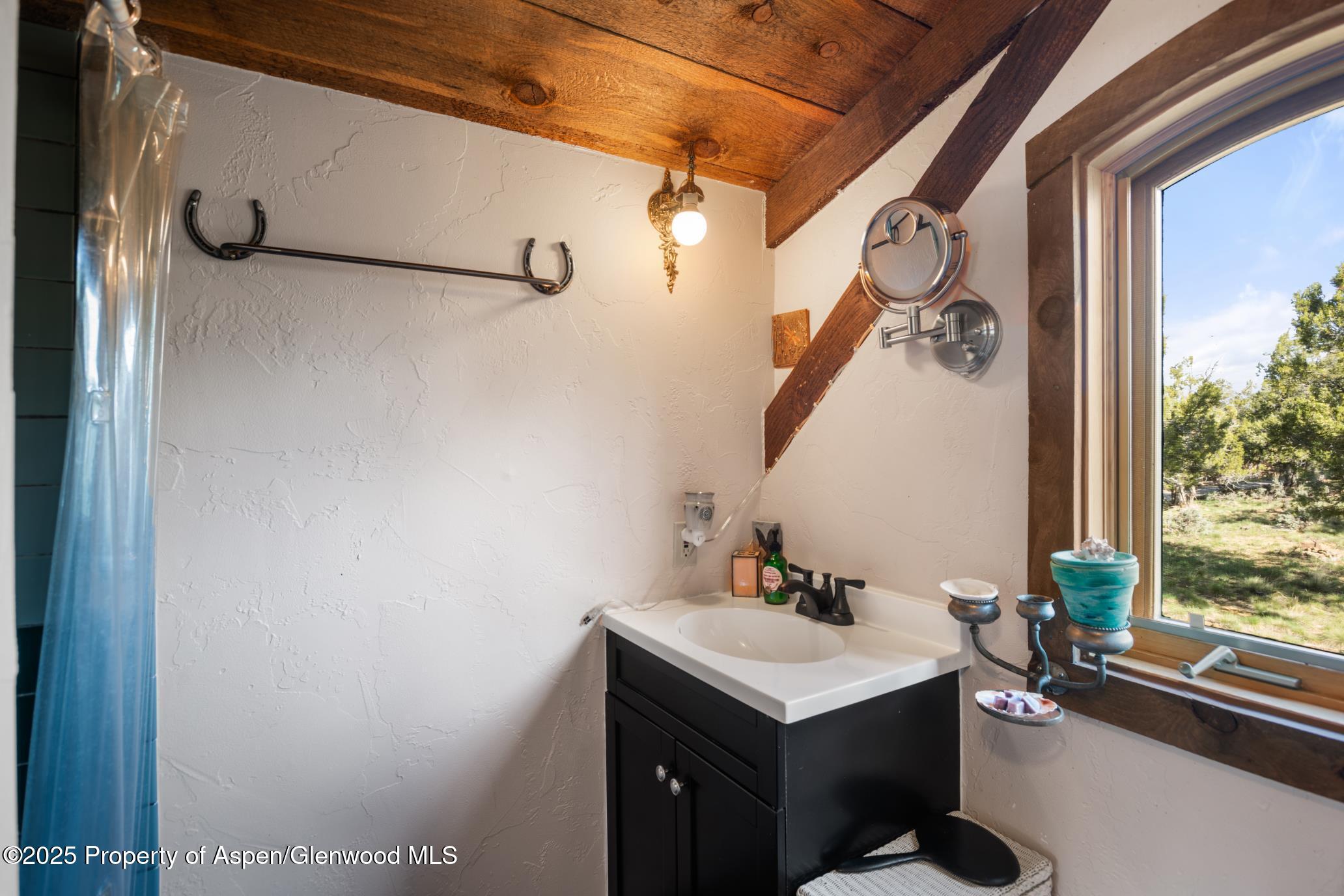 4440 County Road 342 Silt, CO 81652 - Photo 44 of 62 a bathroom with a sink and mirror with window