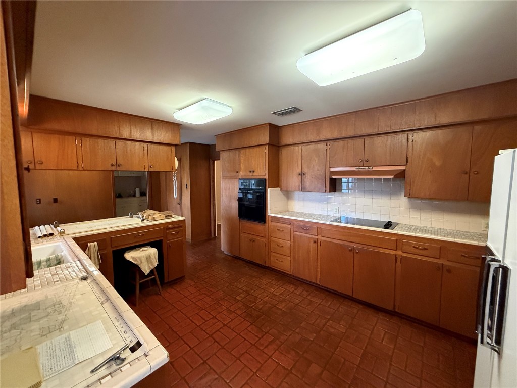 402 Honeycomb Ridge Austin, TX 78746 - Photo 11 of 40 a kitchen with stainless steel appliances granite countertop a sink and cabinets
