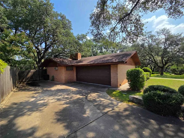 a view of a house with backyard and a tree