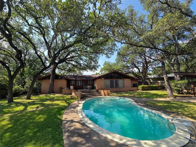 a view of a house with backyard and sitting area