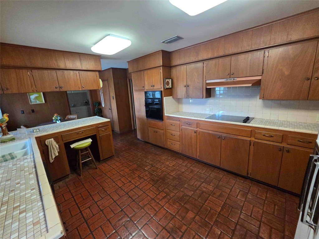 402 Honeycomb Ridge Austin, TX 78746 - Photo 21 of 40 a kitchen with stainless steel appliances wooden cabinets and a sink