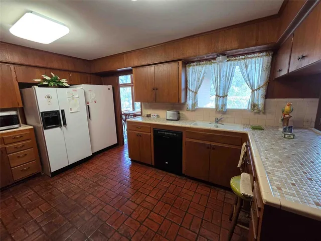 a kitchen with a sink appliances and cabinets