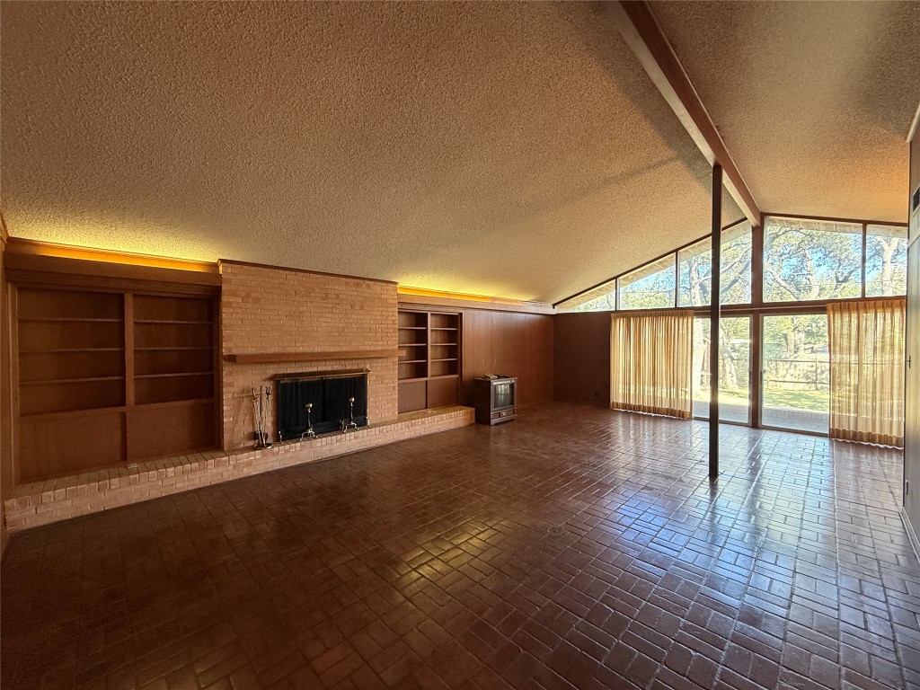 402 Honeycomb Ridge Austin, TX 78746 - Photo 8 of 40 a view of an empty room with wooden floor fireplace and a window