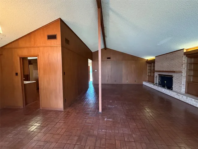 a view of empty room with wooden floor and fireplace