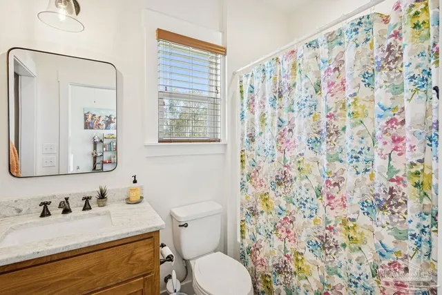 a bathroom with a sink vanity mirror and toilet