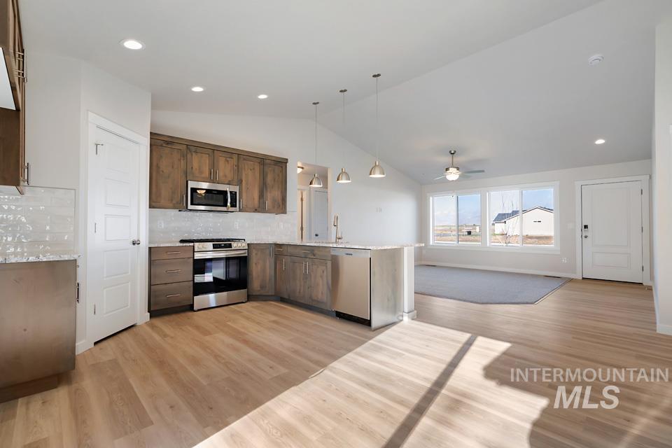 985 Twilight Street Weiser, ID 83672 - Photo 32 of 32 Kitchen featuring decorative light fixtures, open floor plan, stainless steel appliances, a peninsula, and vaulted ceiling