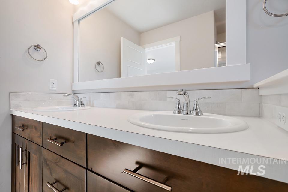 985 Twilight Street Weiser, ID 83672 - Photo 16 of 32 Bathroom with double vanity and decorative backsplash