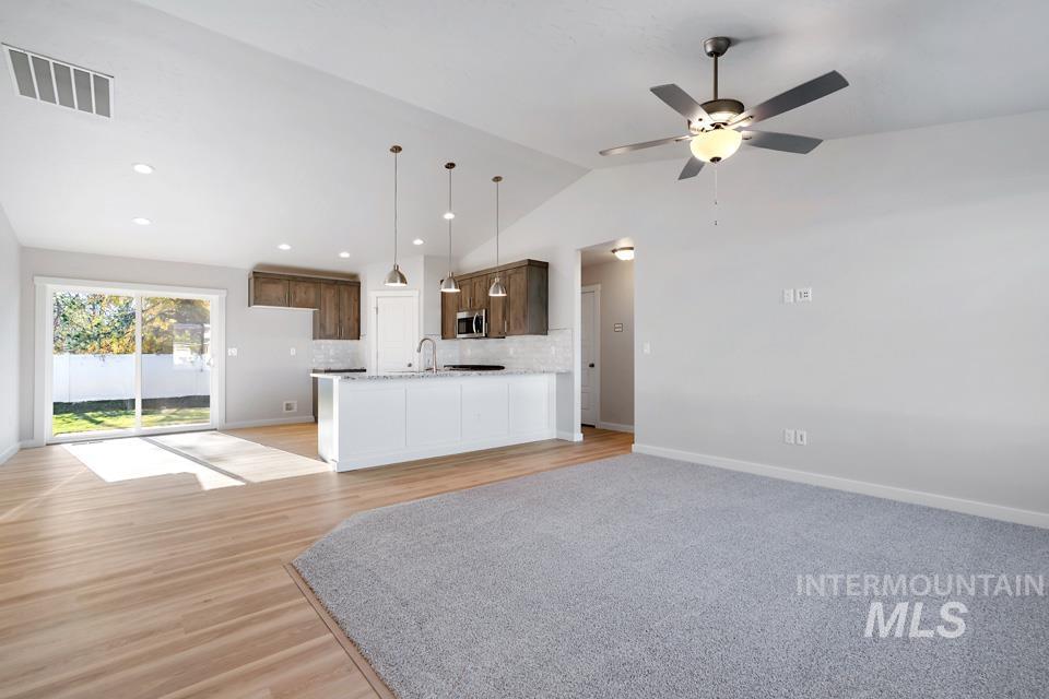 985 Twilight Street Weiser, ID 83672 - Photo 4 of 32 Unfurnished living room with light wood finished floors, lofted ceiling, and ceiling fan
