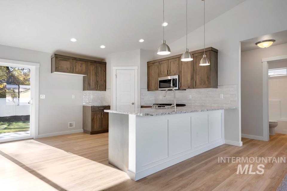 985 Twilight Street Weiser, ID 83672 - Photo 7 of 32 Kitchen featuring a peninsula, light stone counters, decorative light fixtures, light wood finished floors, and recessed lighting