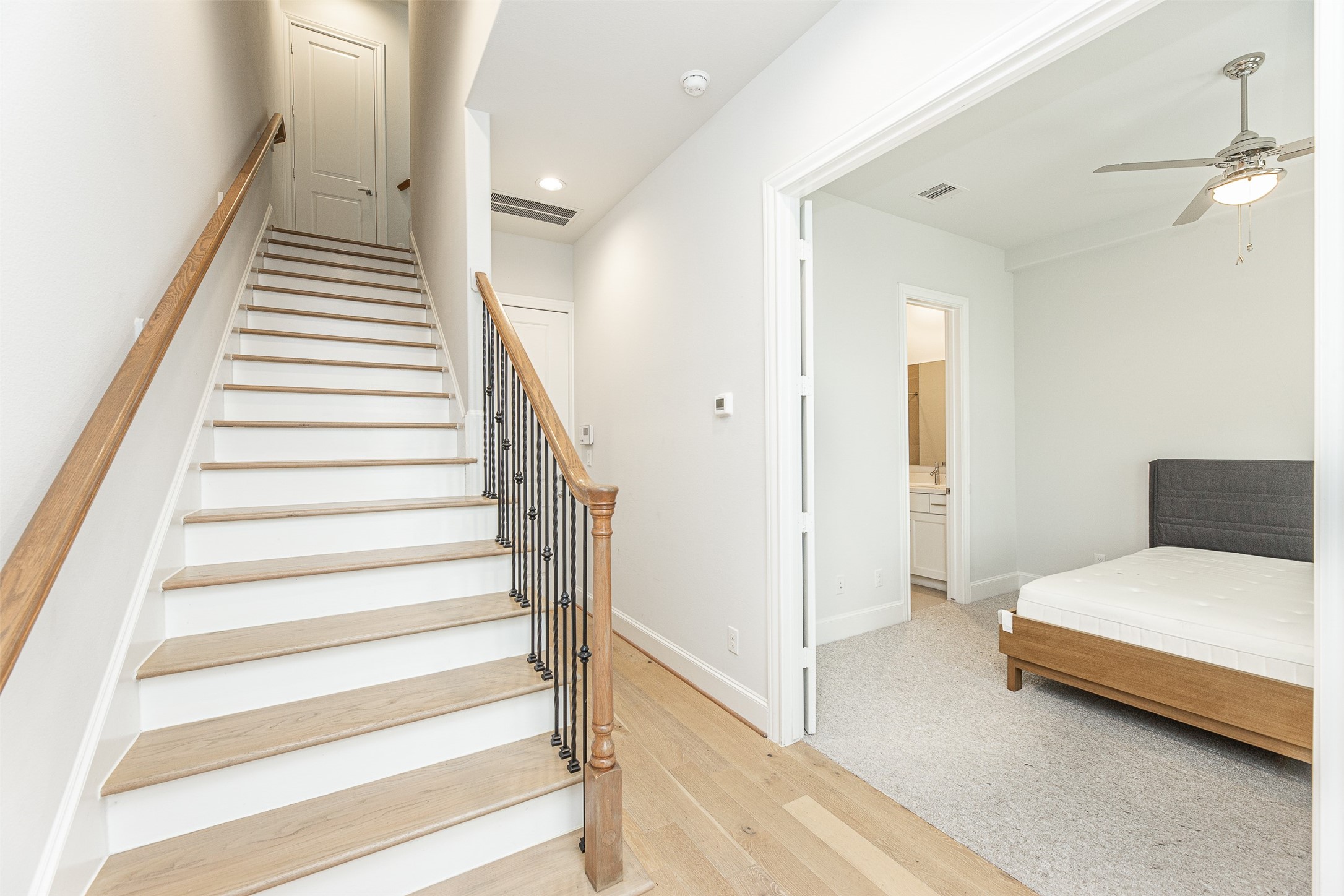 2028 Waterloo Station Road Houston, TX 77045 - Photo 5 of 34 a view of a bedroom with wooden floor and stairs