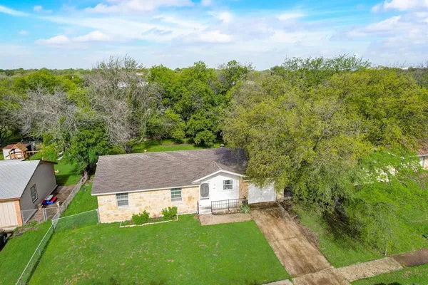 a aerial view of a house with a big yard and large trees