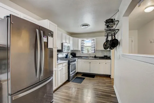 a kitchen with white cabinets and stainless steel appliances